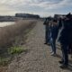 Participants peer through binoculars to observe birds in the marsh.