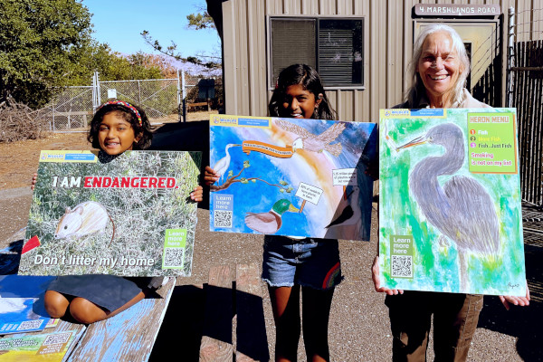 Riya, Isha, and Ranger Tia at Refuge Headquarters in Fremont holding three of Riya's posters. Photo courtesy: Olivia Poulos/SFBWS.